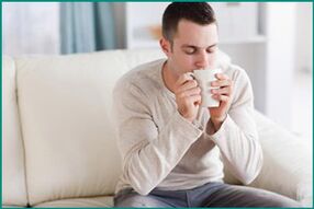 Un uomo beve tè alla menta, volendo curare la disfunzione erettile. 